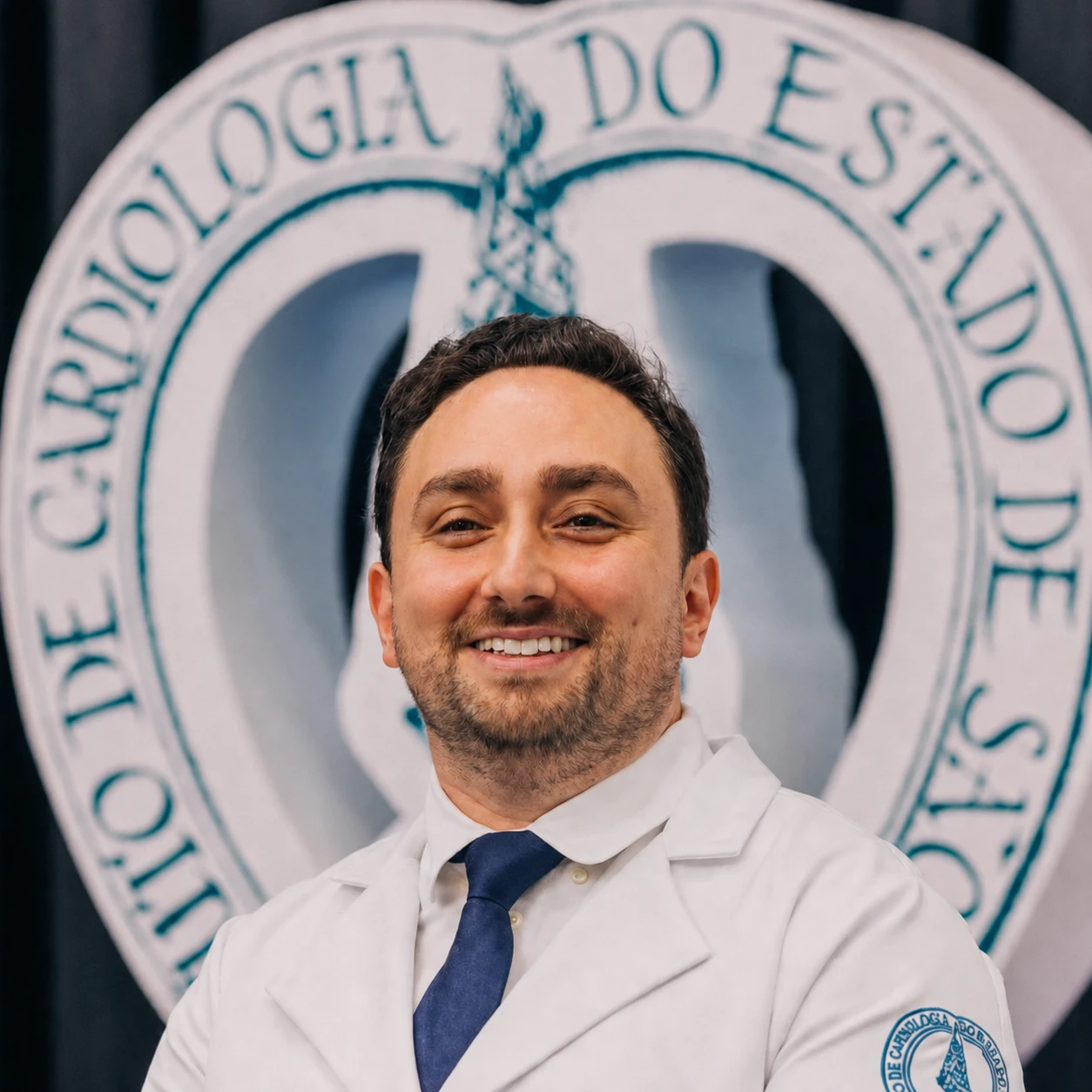 Dr. Victor Rosalem Senese de jaleco branco e gravata azul